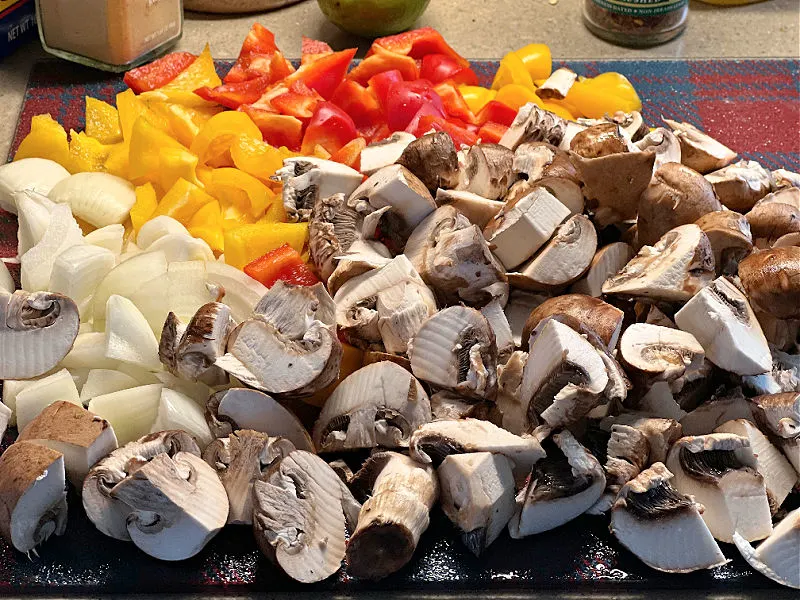 chopped mushrooms bell pepper and onion on a cutting board