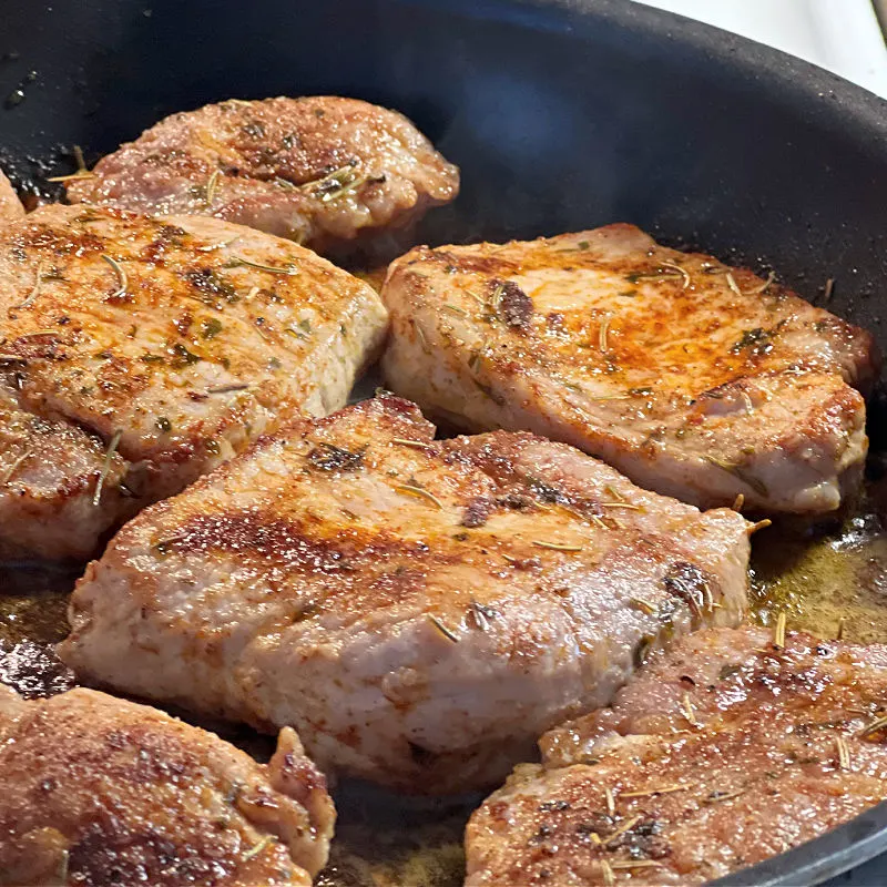 browning pork chops in a skillet