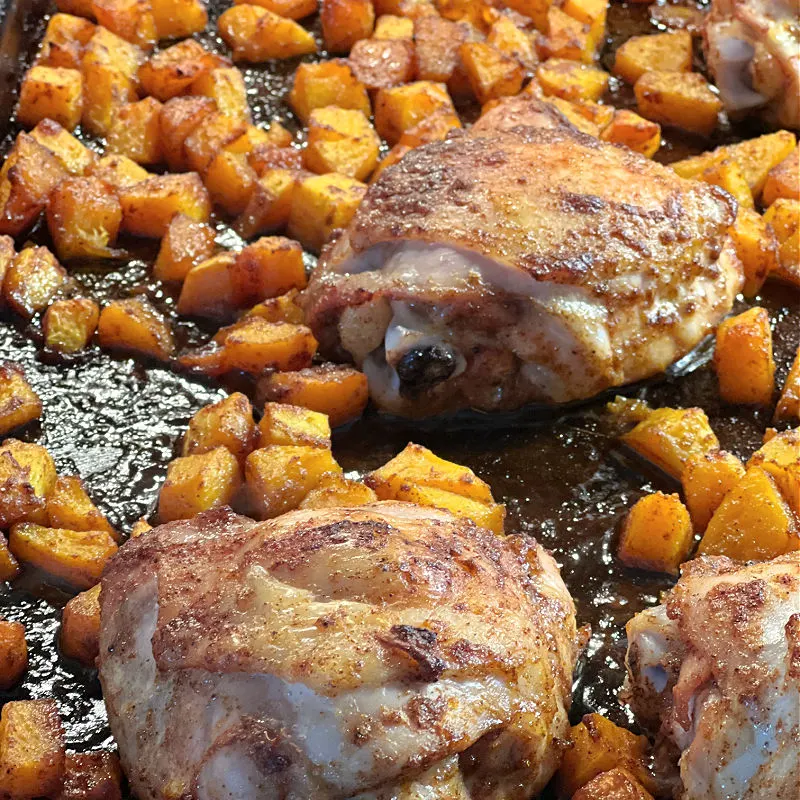 cooked chicken and squash on the baking pan