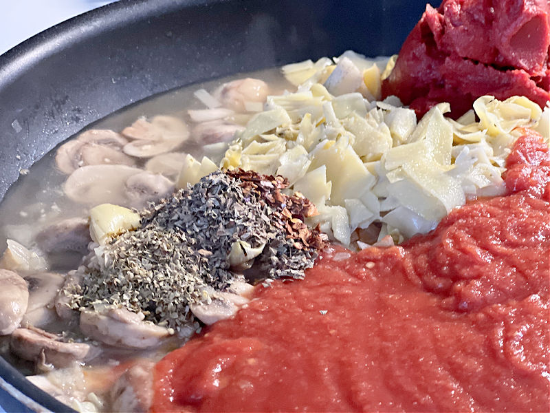 add the tomatoes, artichokes, broth, and seasonings to the pan