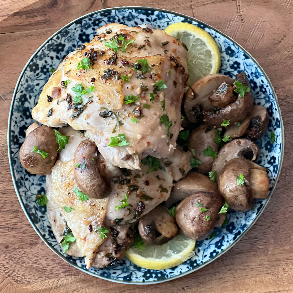 chicken and mushrooms with sliced lemon and parsley