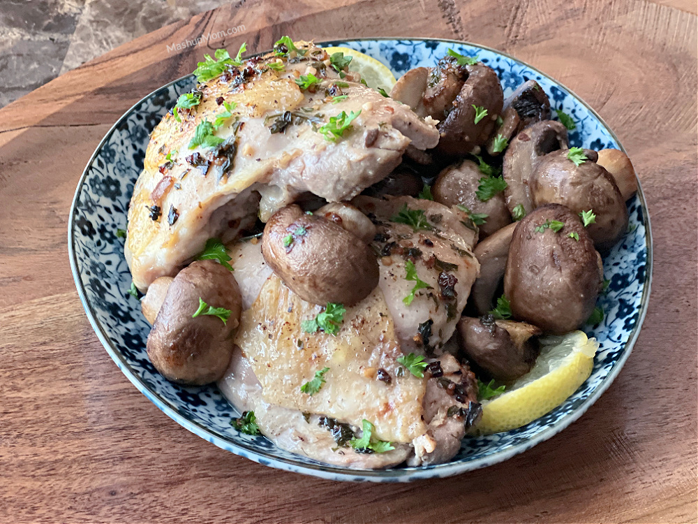 lemon garlic chicken thighs on a plate with mushrooms