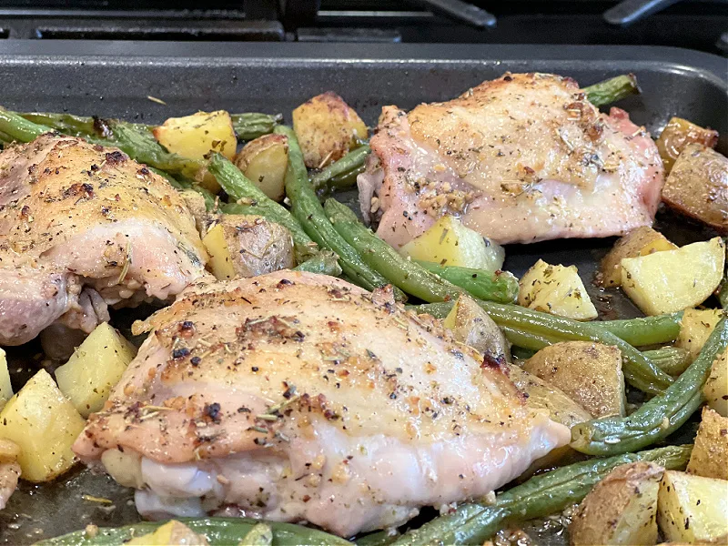 roasted chicken green beans and potatoes on pan