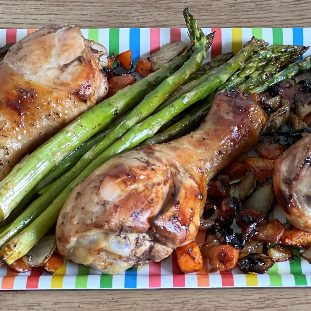 drumsticks, carrots, onions, asparagus on a plate