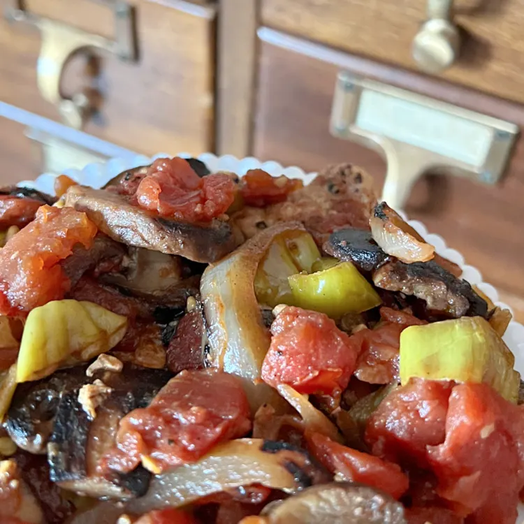 plate of pork chops with peppers tomatoes and mushrooms