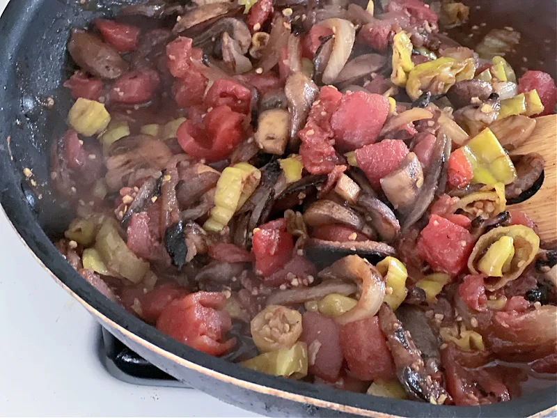 tomatoes, mushrooms, and pepperoncini cooked down in the pan
