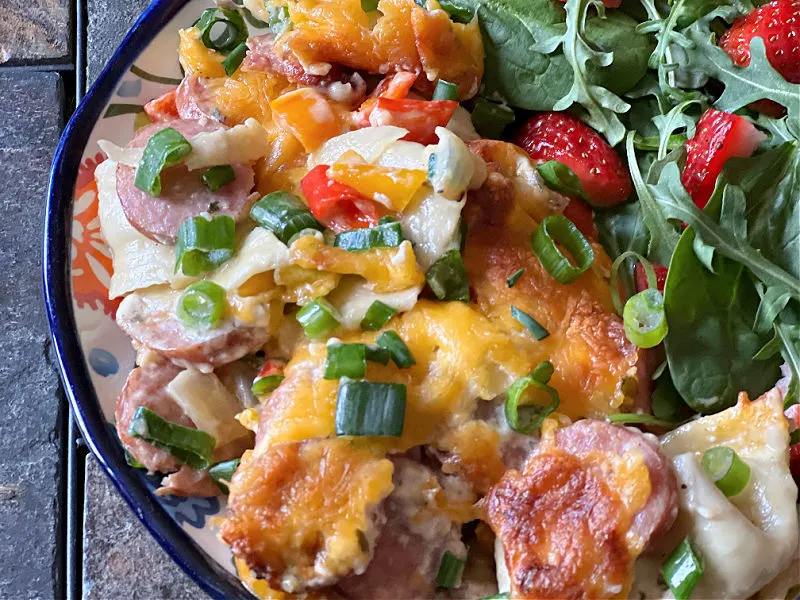 pierogie casserole on a plate with strawberry spinach salad