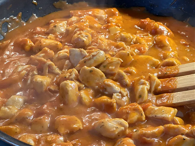 cooked chicken in the skillet with sauce