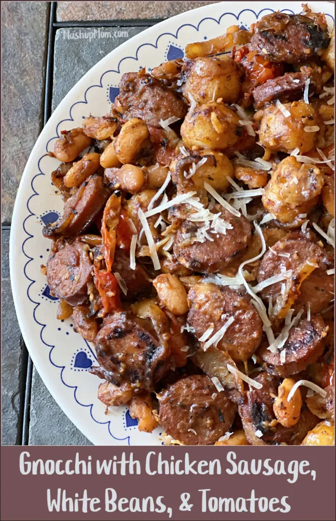 gnocchi with chicken sausage, white beans, and tomatoes, on a white plate with blue hearts