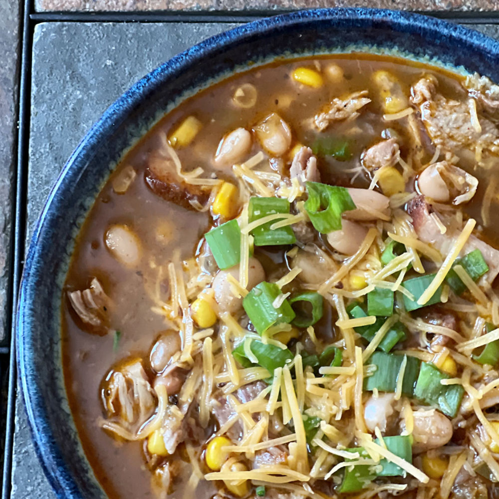pork chili topped with cheese and chopped green onion