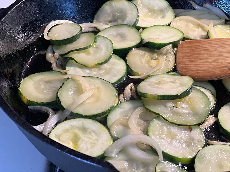 sauteed zucchini and onion in a cast iron skillet