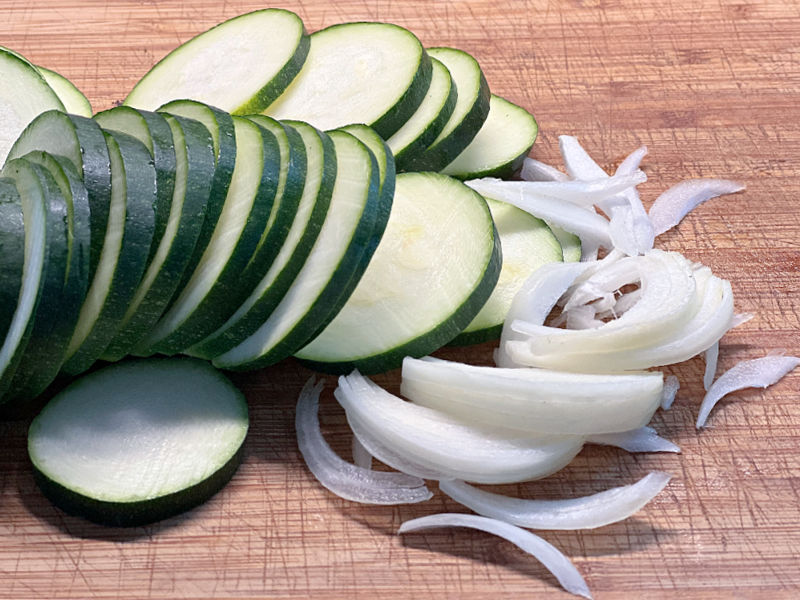 sliced zucchini and onion on a cutting board